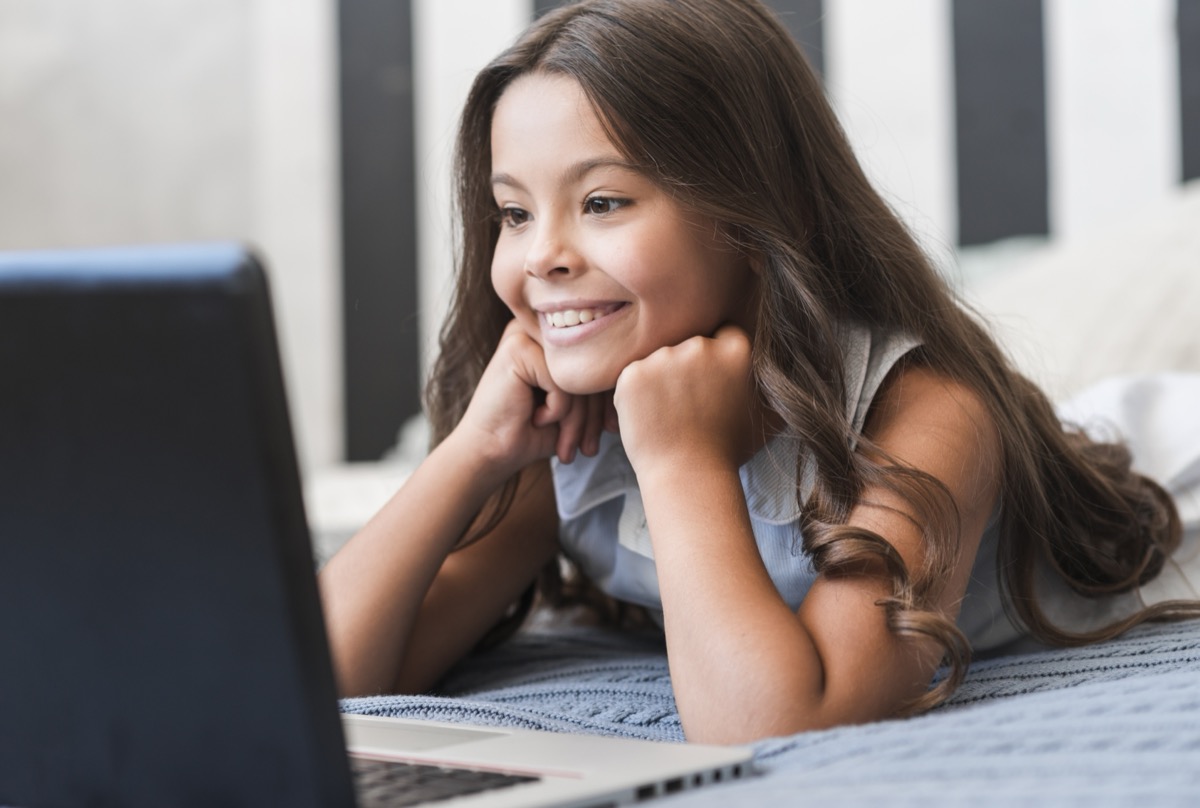 Girl smiling while working on a laptop
